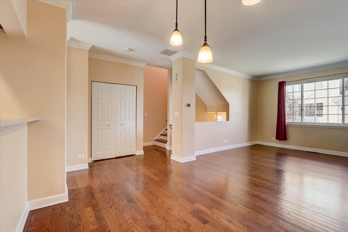 3372 Ravinia Circle Aurora, IL 60504 - Photo 4 of 39 a view of an empty room with wooden floor and windows