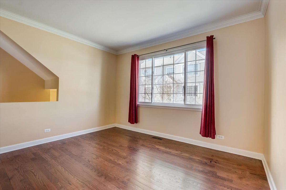 3372 Ravinia Circle Aurora, IL 60504 - Photo 5 of 39 a view of an empty room with wooden floor and a window