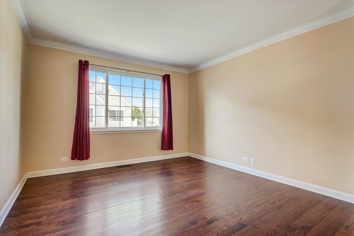 3372 Ravinia Circle Aurora, IL 60504 - Photo 6 of 39 a view of an empty room with wooden floor and a window