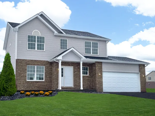 a front view of a house with a garden and yard