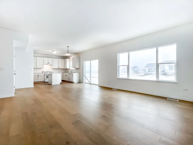 a view of kitchen and hall with wooden floor