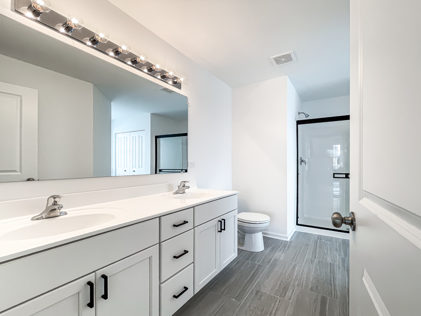 895 Willow Road Manteno, IL 60950 - Photo 9 of 14 a spacious bathroom with a double vanity sink a mirror and a toilet