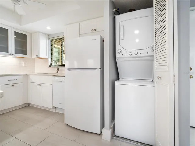 a kitchen with a refrigerator sink and cabinets