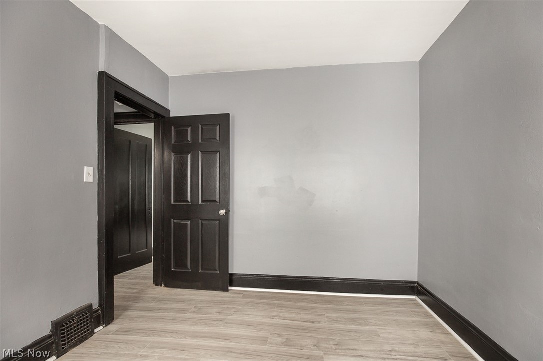 1868-1870 Lampson Road Cleveland, OH 44112 - Photo 31 of 36 Interior room with light gray walls, dark trim, and light wood-finish flooring