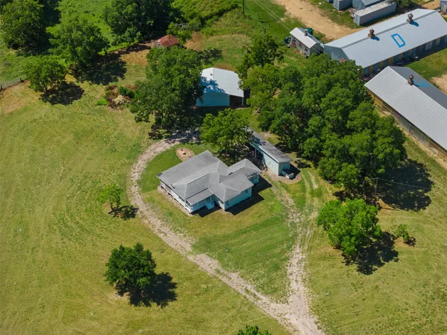 an aerial view of residential house with yard and swimming pool