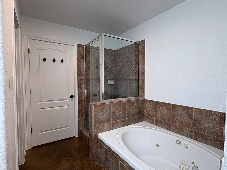 430 Summit Ridge Drive North Point Venture, TX 78645 - Photo 13 of 26 Relax in the inviting jetted tub with tiled surround, adjacent to a glass-enclosed shower.