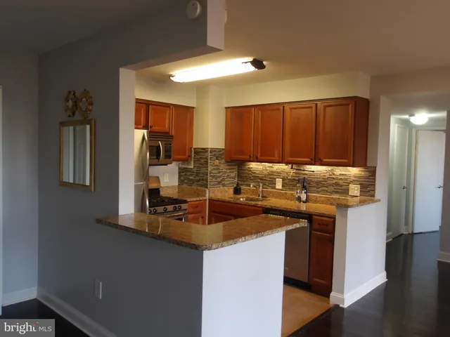 a kitchen with stainless steel appliances granite countertop a sink stove and microwave