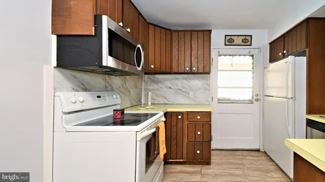a kitchen with stainless steel appliances a stove microwave and refrigerator