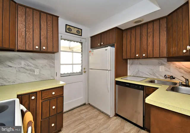 a kitchen with a refrigerator and a stove top oven
