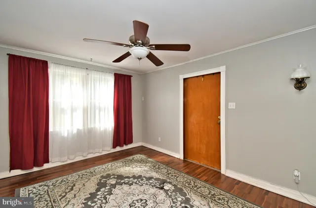 a view of an empty room and window and wooden floor