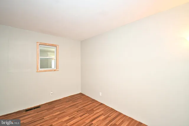 a view of a room with wooden floor and white wall