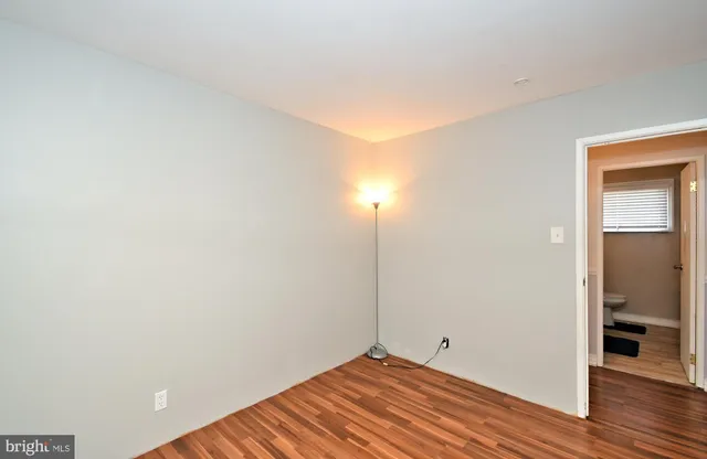 a view of a room with wooden floor and a bathroom