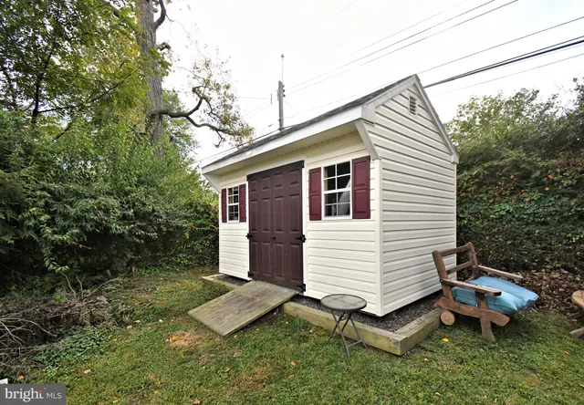 a view of a white house with a yard and sitting area