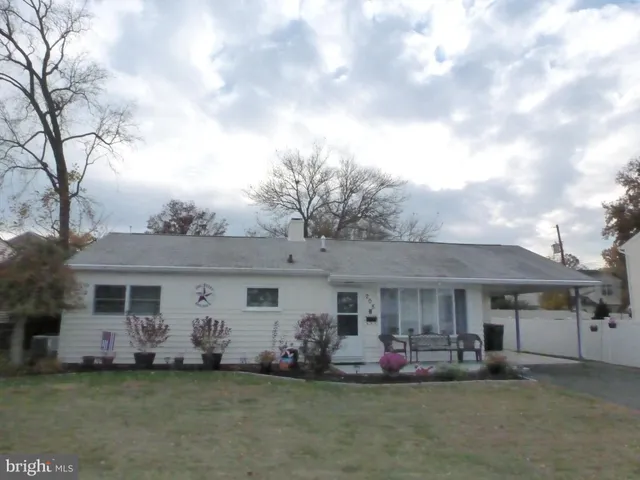 a front view of a house with a garden and fire pit