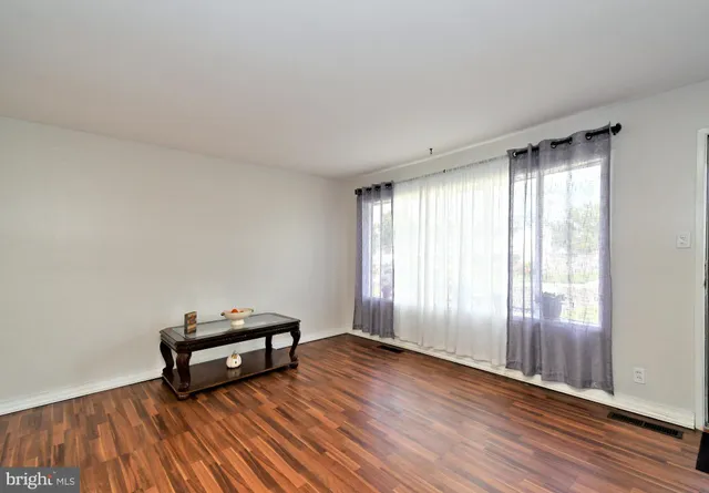 a view of room with wooden floor and lounge chairs