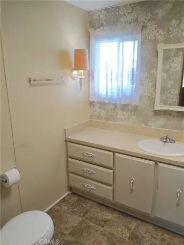 a bathroom with a sink a toilet and window