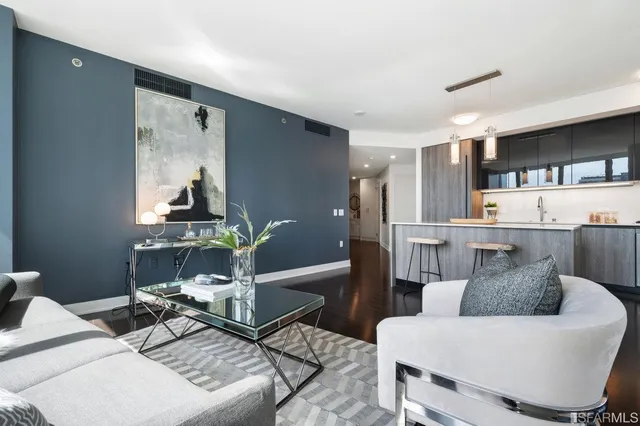 a living room with furniture and a painting on the wall