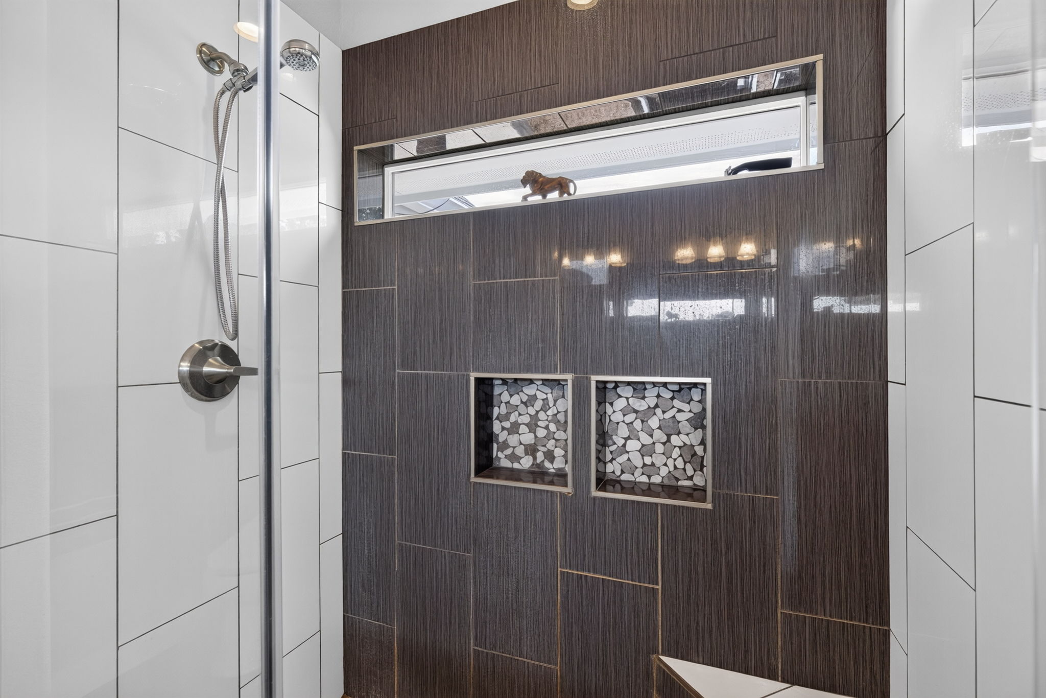 207 Deer Ridge Drive Burnet, TX 78611 - Photo 27 of 36 A well-appointed shower offers modern fixtures and tiled storage nooks for convenience.