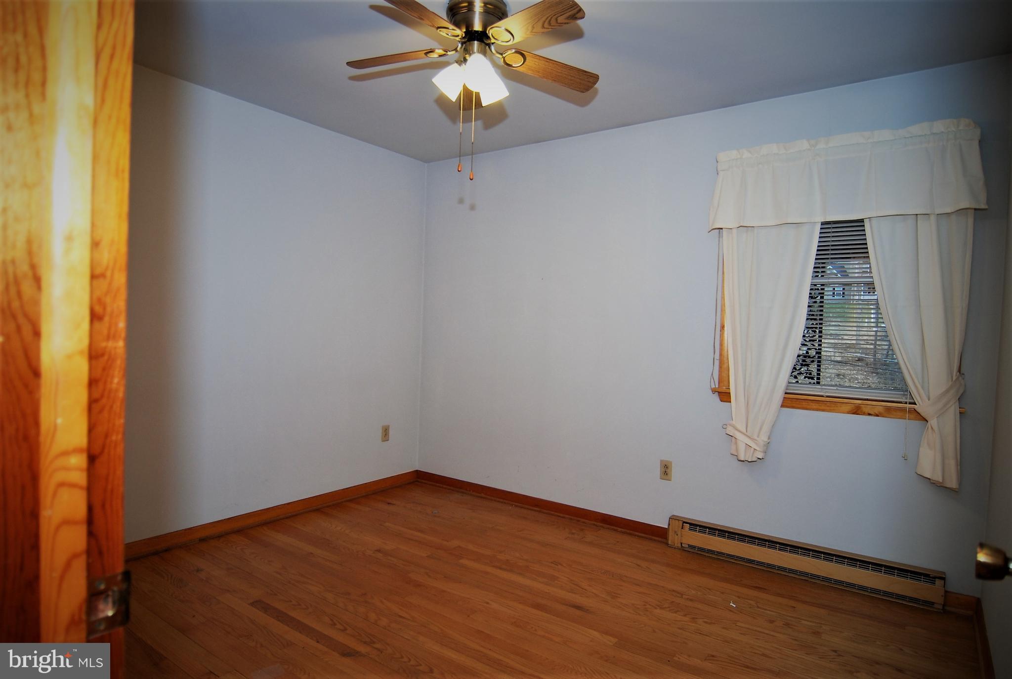 6712 South Clifton Road Frederick, MD 21703 - Photo 12 of 28 an empty room with wooden floor fan and windows
