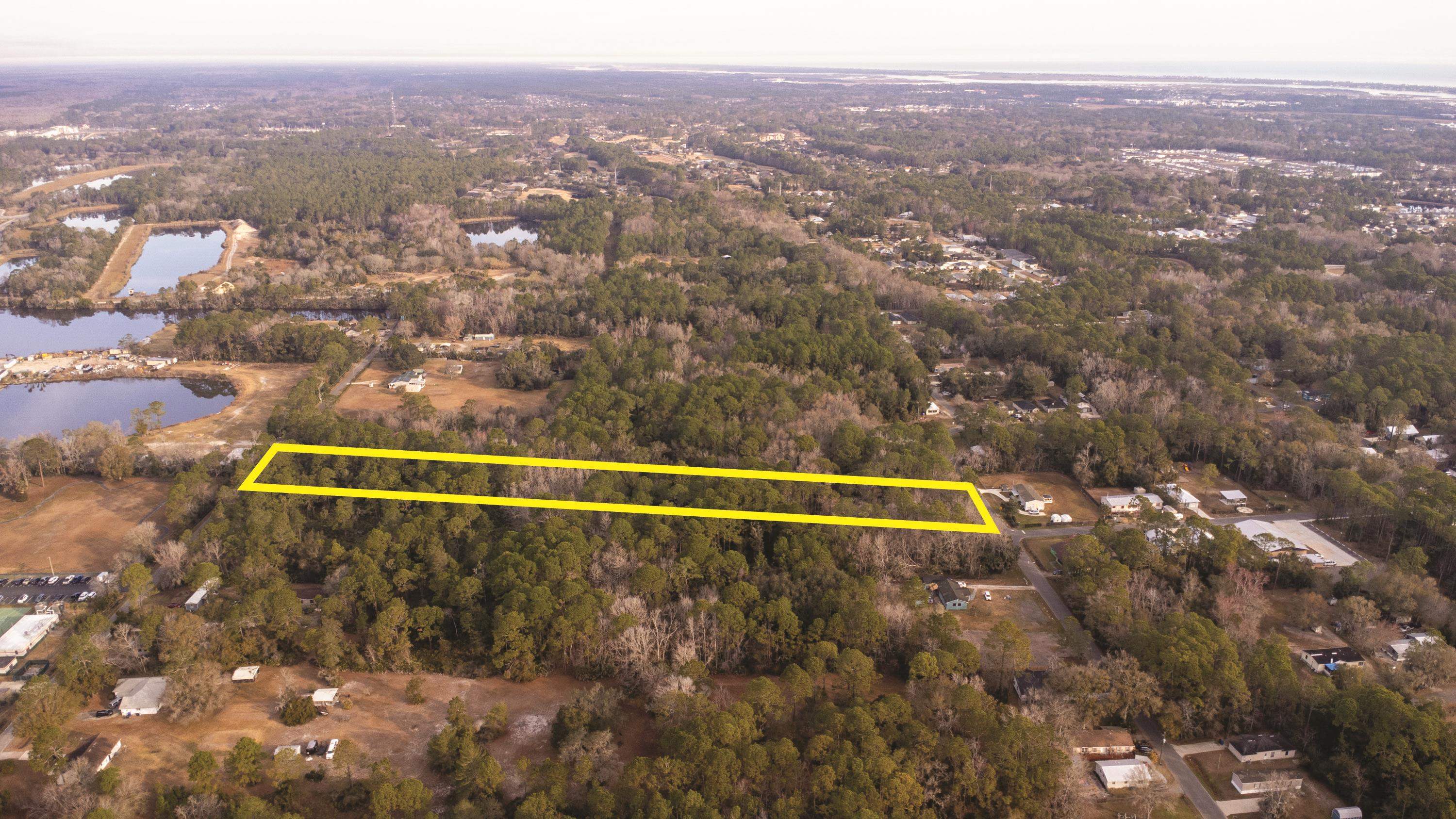 Aerial view of property and surrounding area featuring a nearby body of water and property boundaries highlighted