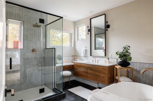 a bathroom with a tub shower and sink