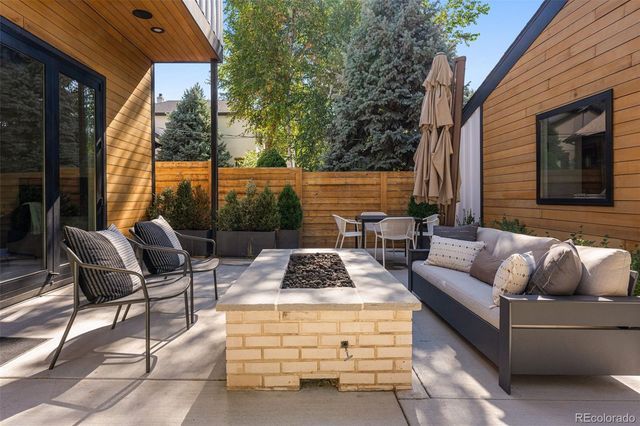 a view of a house with potted plants and a bench