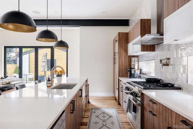 a kitchen with stainless steel appliances a sink a stove and a wooden floors