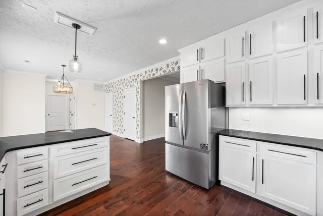 a kitchen with granite countertop white cabinets and stainless steel appliances