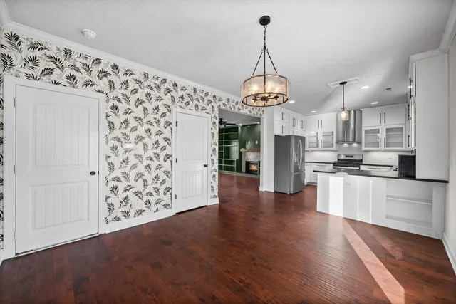 a view of a kitchen with refrigerator and wooden floor
