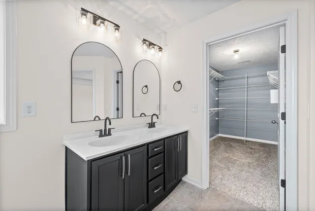 a bathroom with a double vanity sink mirror and shower