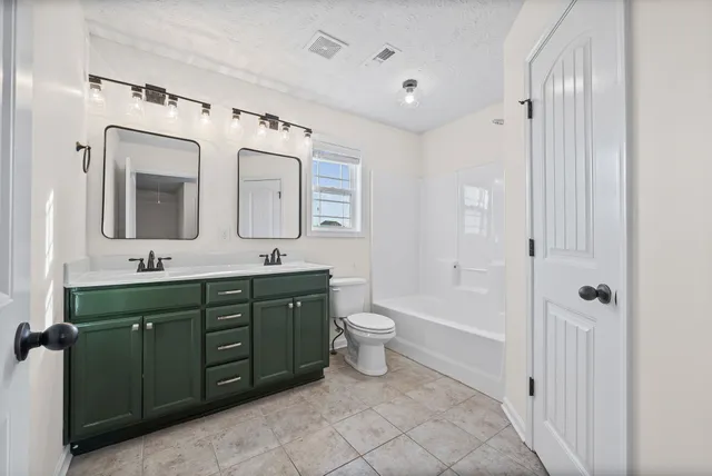 a spacious bathroom with a toilet sink and mirror