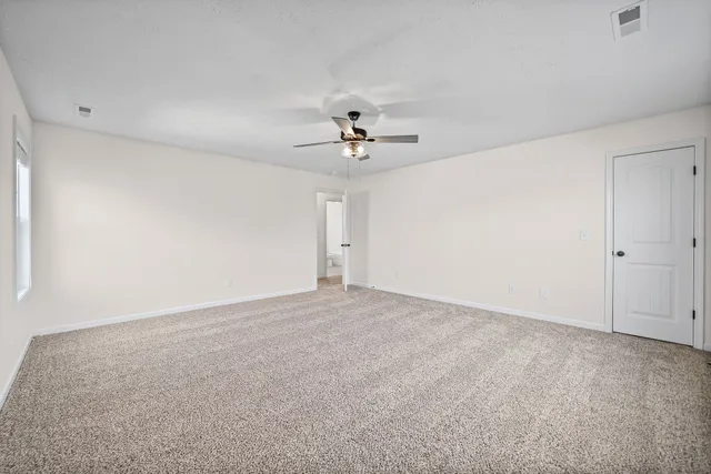 a view of an empty room with a ceiling fan