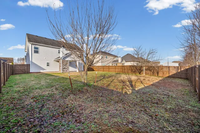 a view of a backyard with wooden fence