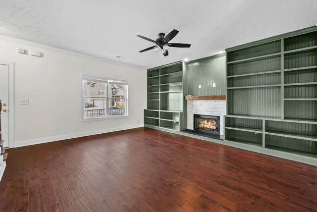 a view of an empty room with a window and fireplace