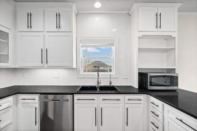 a kitchen with granite countertop white cabinets and white appliances