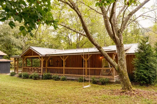 a view of a house with a yard balcony and tree