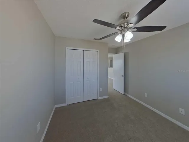 an empty room with a fan and a fan