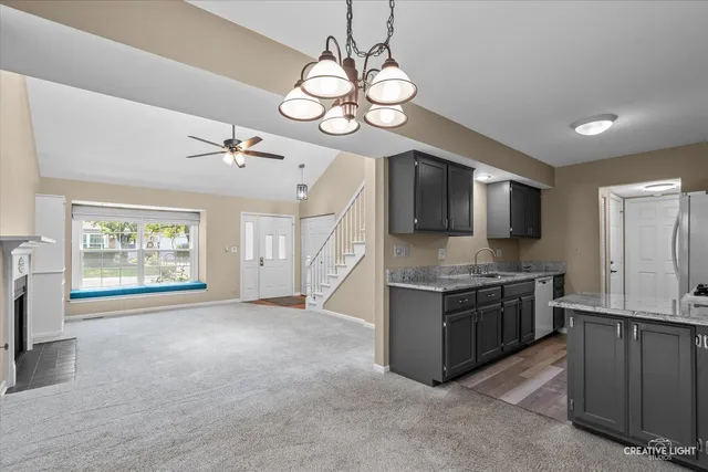 a kitchen with stainless steel appliances granite countertop a sink a stove top oven a counter space and cabinets