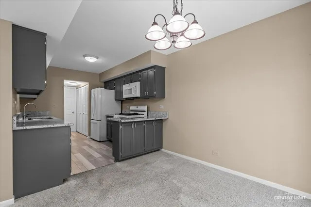 a kitchen with granite countertop a refrigerator and a stove top oven