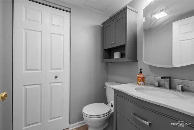 a view of an empty room with wooden floor and fan