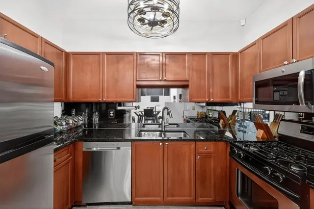 a kitchen with stainless steel appliances granite countertop a sink stove and microwave