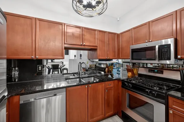 a kitchen with stainless steel appliances granite countertop a stove microwave and sink with cabinets