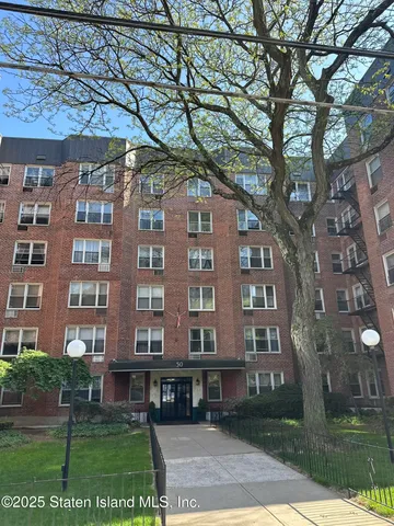 front view of a residential apartment building with a yard