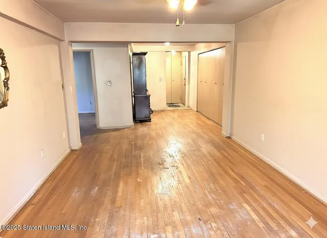 a view of empty room with wooden floor