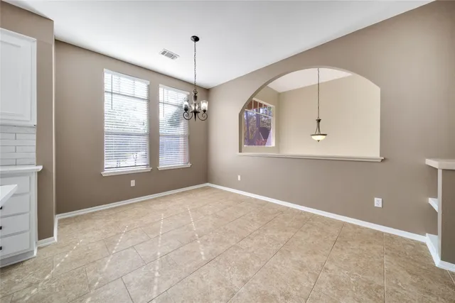 an empty room with a ceiling fan and windows