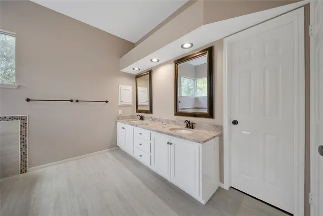 a view of an empty room with wooden floor and a ceiling fan