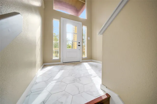 a view of a hallway with wooden floor and windows