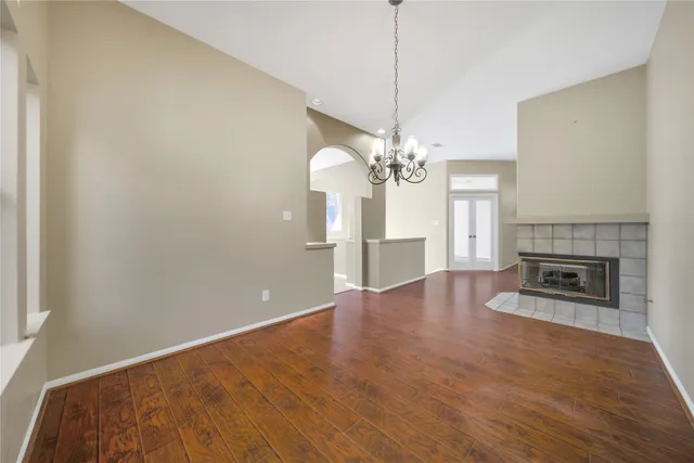 a view of a livingroom with a fireplace a chandelier a wooden floor and chandelier