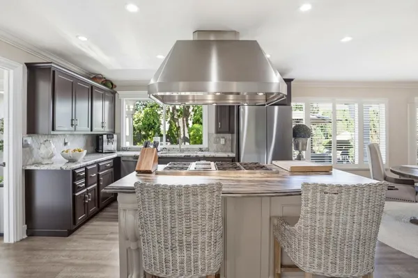 a kitchen with stainless steel appliances granite countertop a stove a sink and a refrigerator