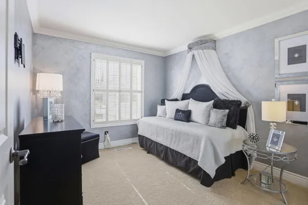 a bedroom with a bed a table and a window